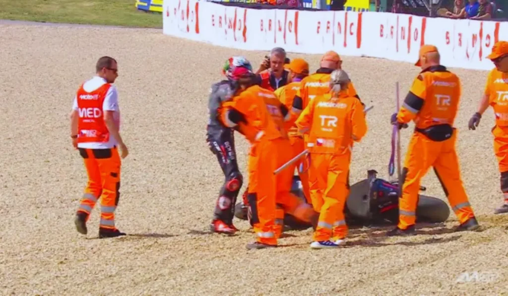 Bezzecchi leader Mondiale abbraccia commosso il marshall Ladislav dopo le scuse per l'incidente a Brno.