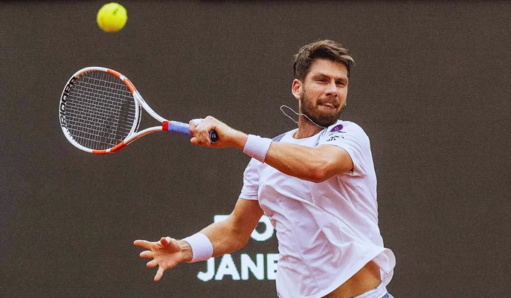 Cameron Norrie in azione durante match su erba a Wimbledon