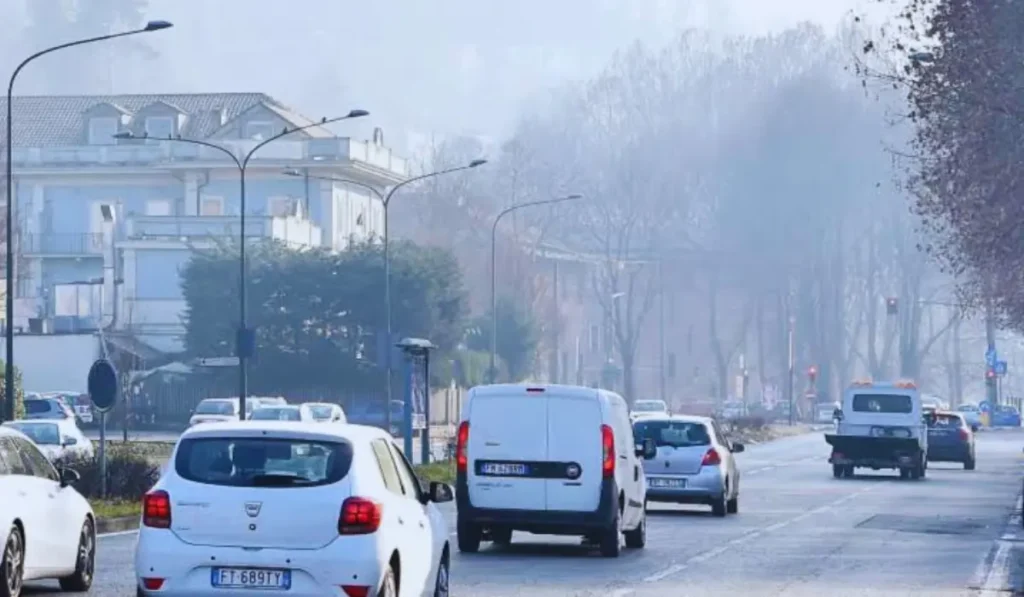 Cartello di zona a traffico limitato con veicoli in strada