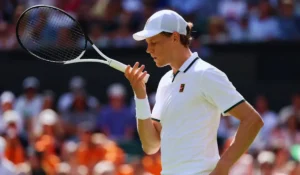 Jannik Sinner in azione sul Centre Court di Wimbledon con il piede ferito