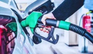 Automobilista al distributore con serbatoio mentre fa rifornimento più caro
