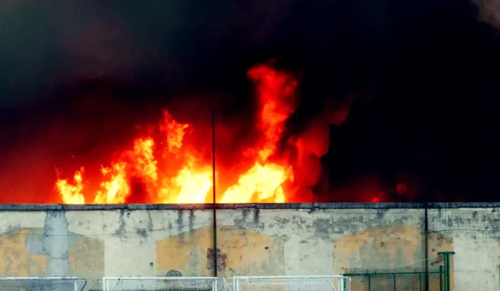 Maxi incendio in zona Bovisa a Milano con una gigantesca colonna di fumo nero visibile sopra la città
