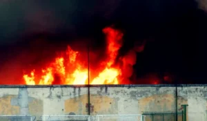 Maxi incendio in zona Bovisa a Milano con una gigantesca colonna di fumo nero visibile sopra la città