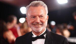 Sam Neill attore Jurassic Park durante una scena iconica del film