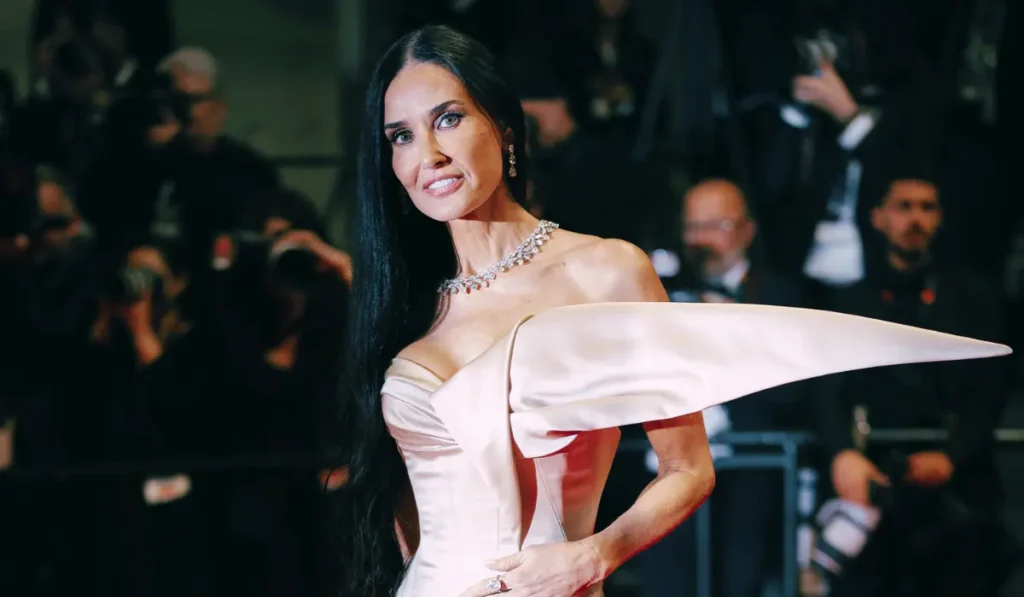 Demi Moore con outfit elegante arricchito da dettagli in pizzo durante un evento di moda