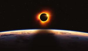 Eclissi solare parziale visibile al tramonto con la Luna che copre il disco del Sole